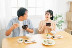 夫婦が食卓で笑顔で食事をしているシーン