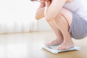 体重計に乗る女性の足元の画像