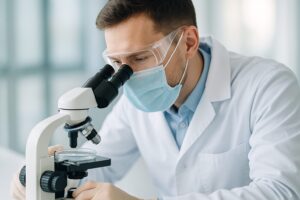 培養皿に顕微鏡で向き合う医師や研究者