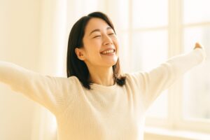 ストレスから解放され笑顔の女性が伸びをしている